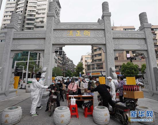  4月16日，進出武漢漢正街步行街的人員在掃描健康碼。新華社記者 王毓國 攝